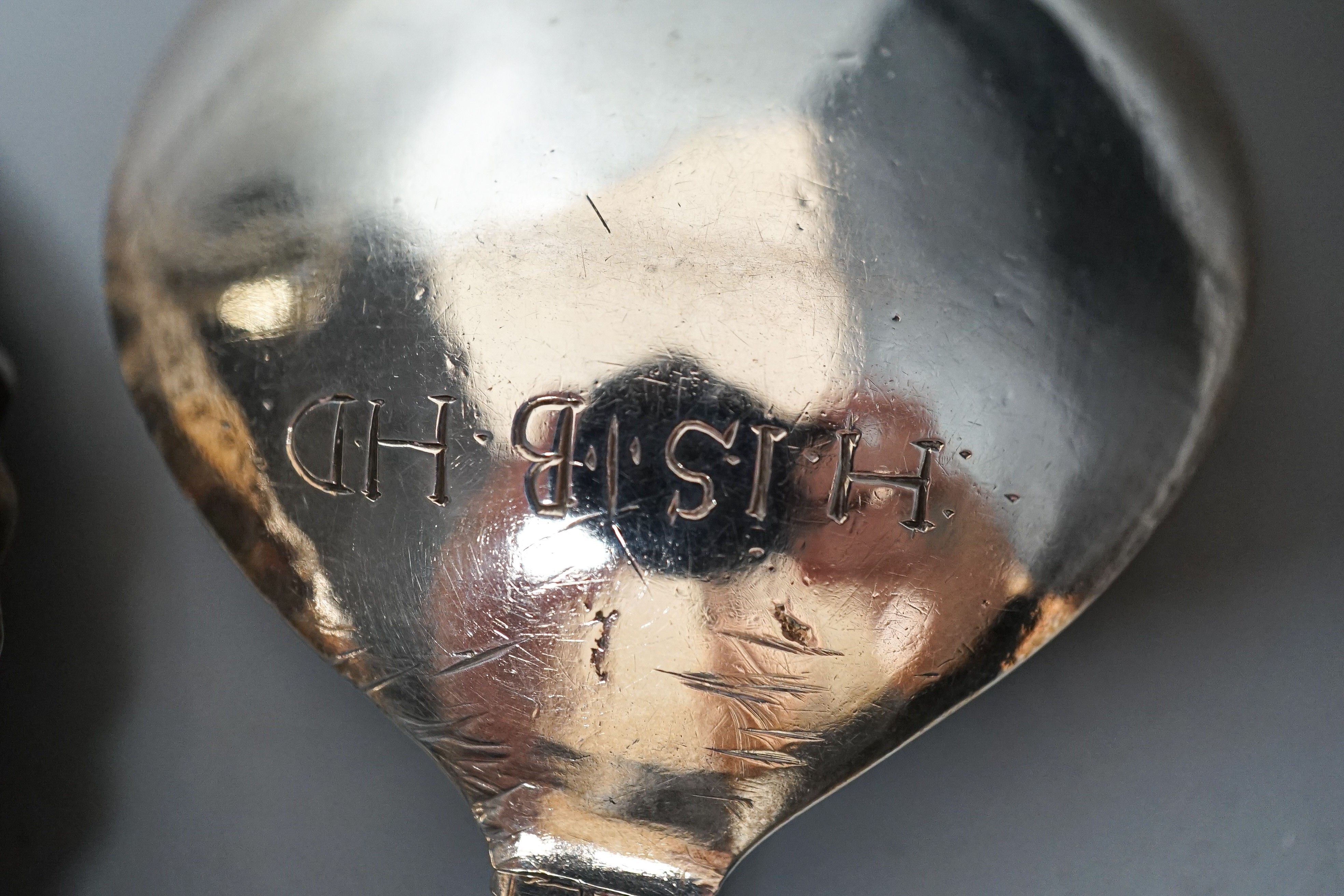 A 19th century Dutch embossed white metal spoon, 13.5cm, one other unmarked white metal spoon, a small silver posy vase and a repousse silver match sleeve.